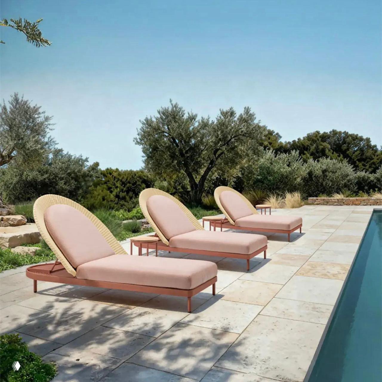 Шезлонги с пастельными розовыми матрасами на террасе у бассейна, терракотовые оттенки и оливковые деревья рядом.