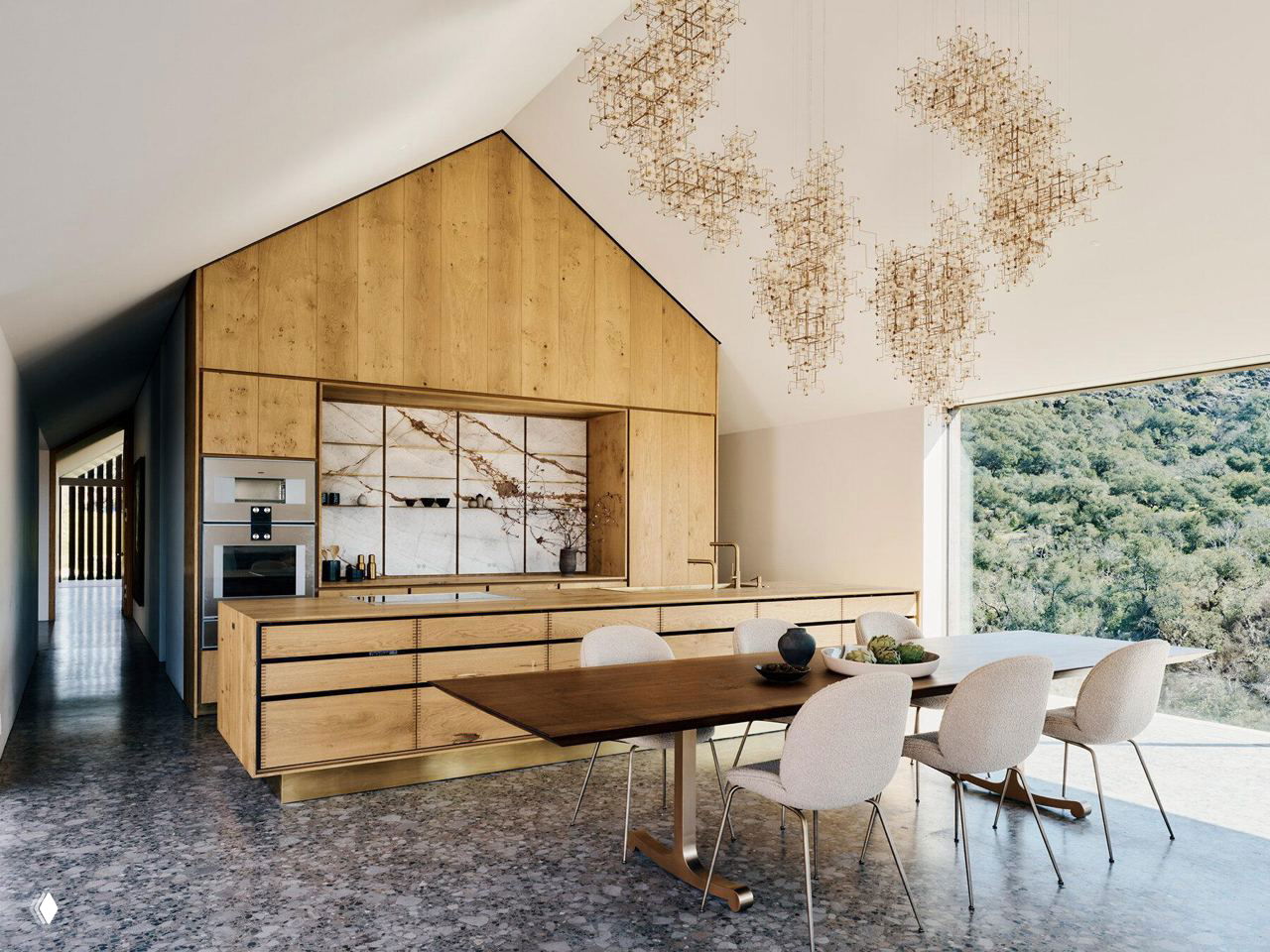 Кухонная зона с дубовой отделкой: встроенные шкафы, остров и столовая, крупные окна открывают вид на зелёные склоны и долину Напа.