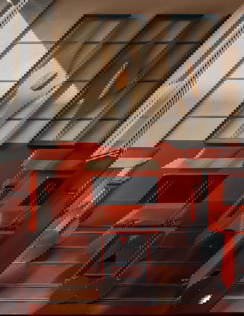 Столы на рельсах внутри кафе: металлические столы и колесики, компактные стулья и красные акценты в отделке создают мобильную сетку посадки.