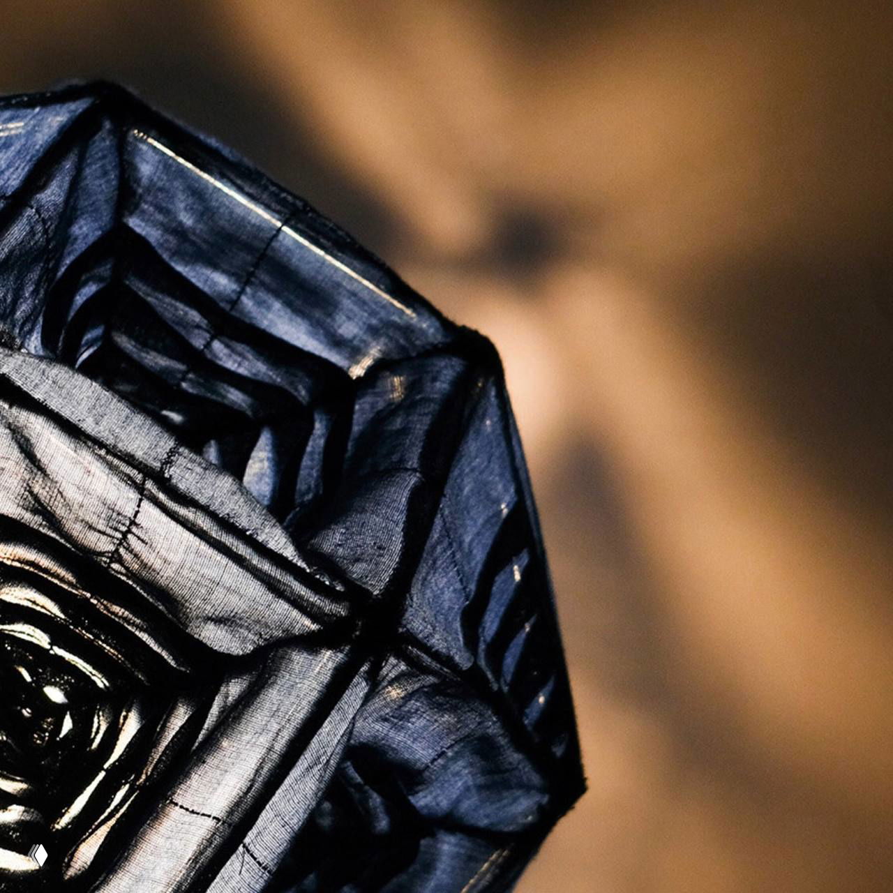 Нижний ракурс лампы Aoi, на котором видно, как свет формирует на стене калейдоскопические теневые орнаменты из 24 граней.