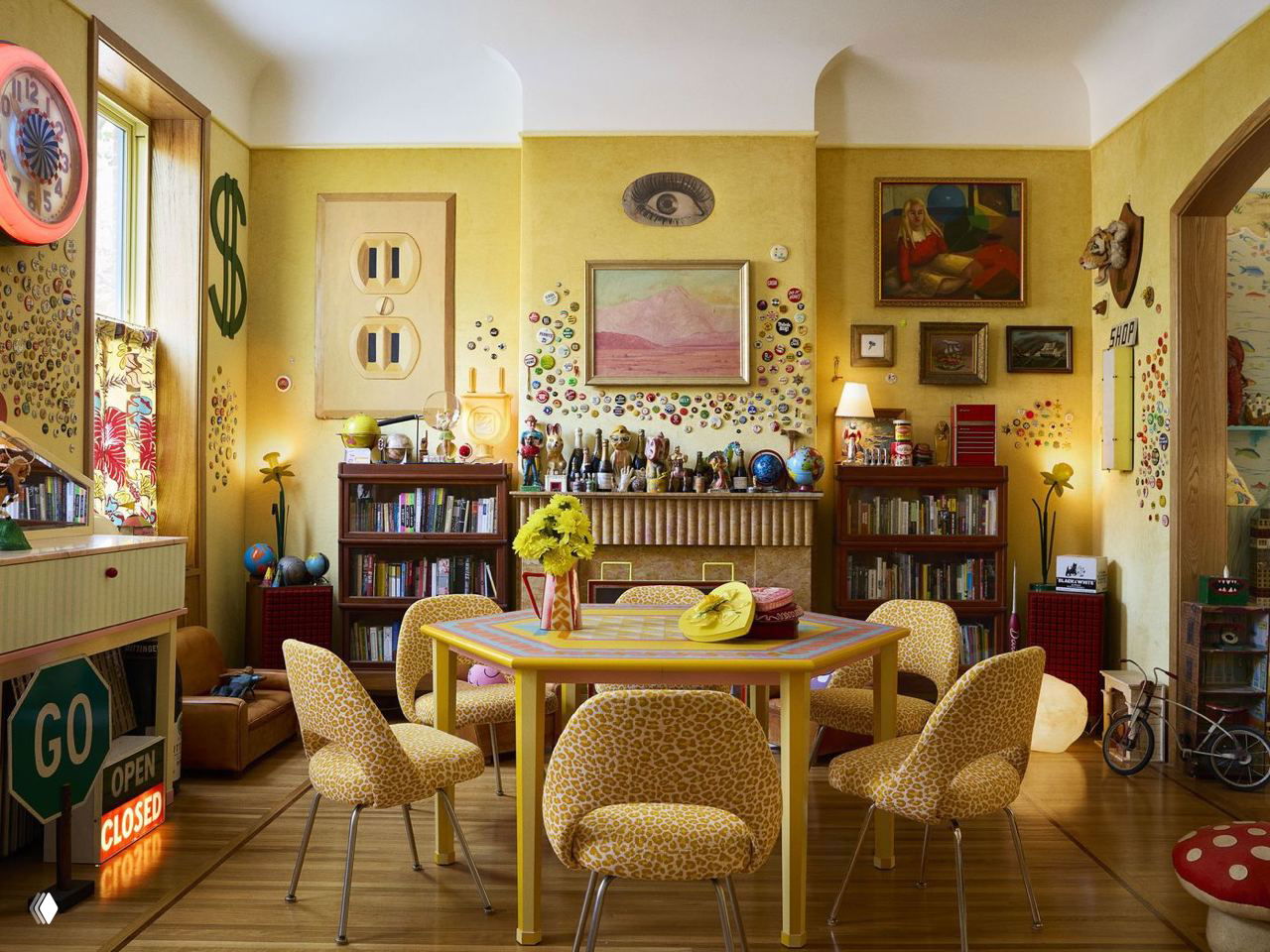 Столовая с желтыми бархатными обоями, столом в желтых тонах и полками с коллекциями — множество декоративных деталей и винтажных предметов.