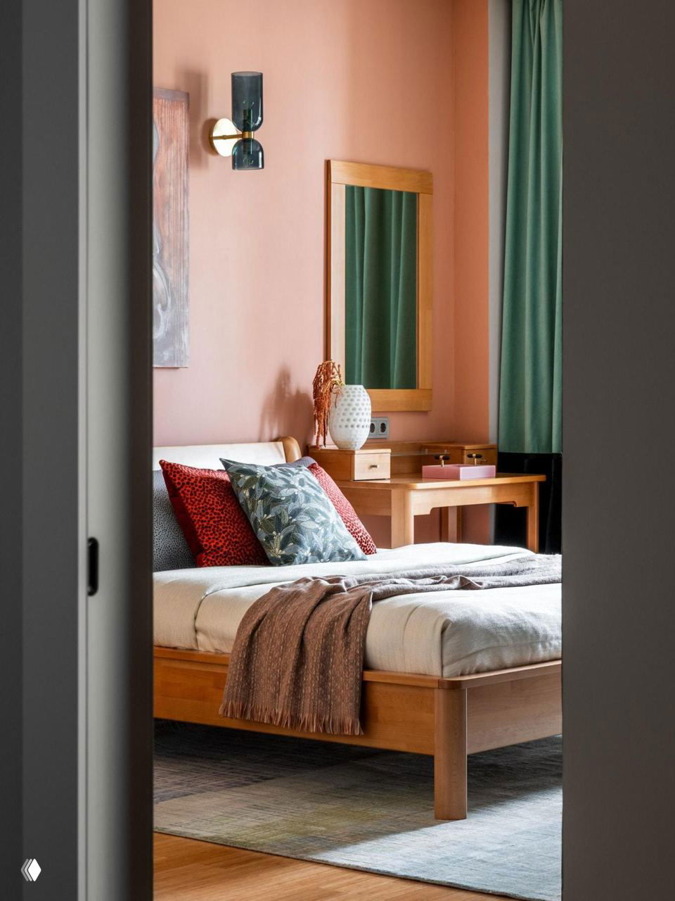 Спальня с персиковой окраской стены, деревянной кроватью и комодом; текстиль в спокойных тонах создаёт тёплую атмосферу.