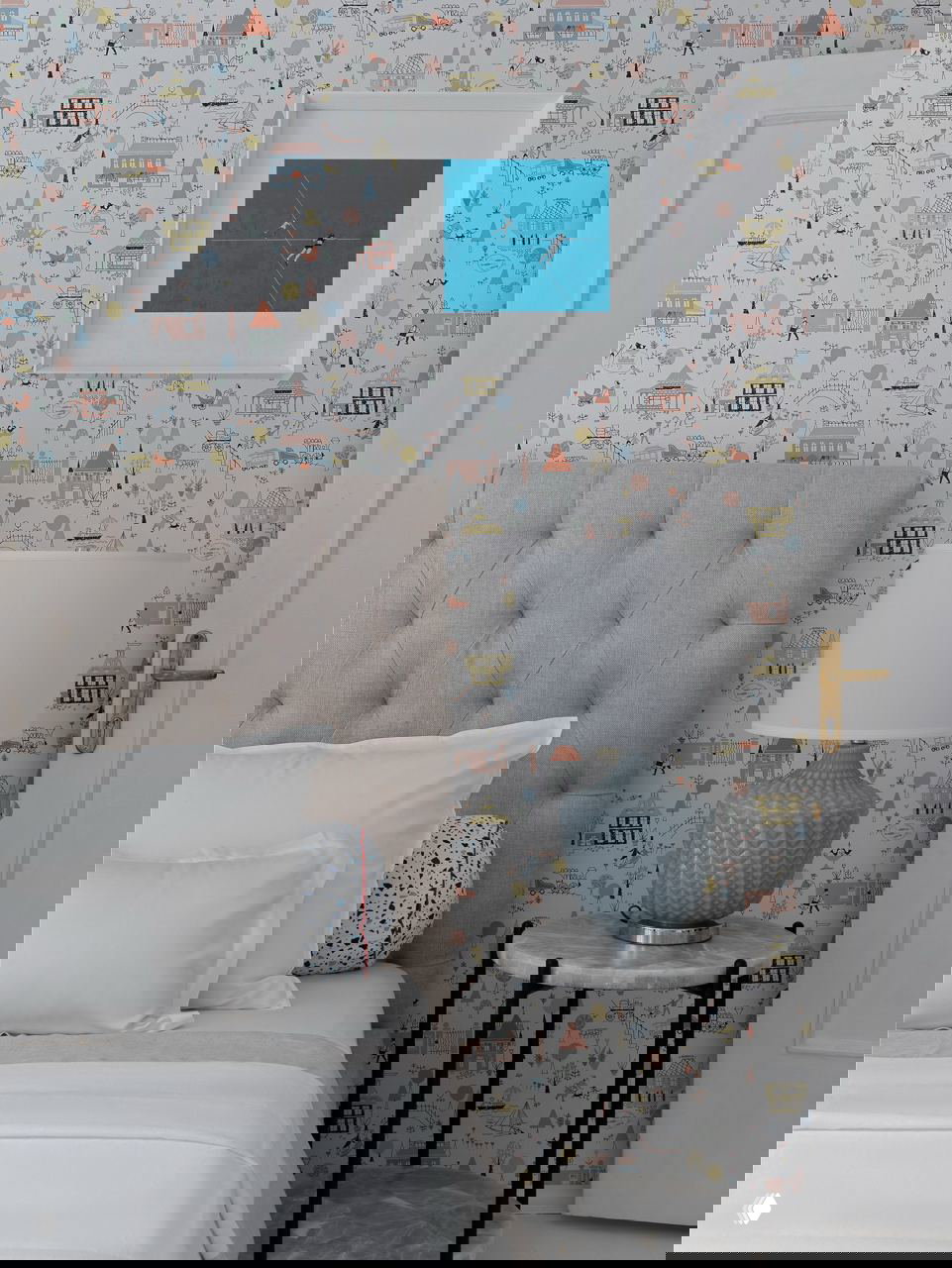 Фрагмент детской спальни с рисунчатыми обоями, мягкой кроватью и прикроватной лампой — акцент на декоративных элементах и уютной атмосфере