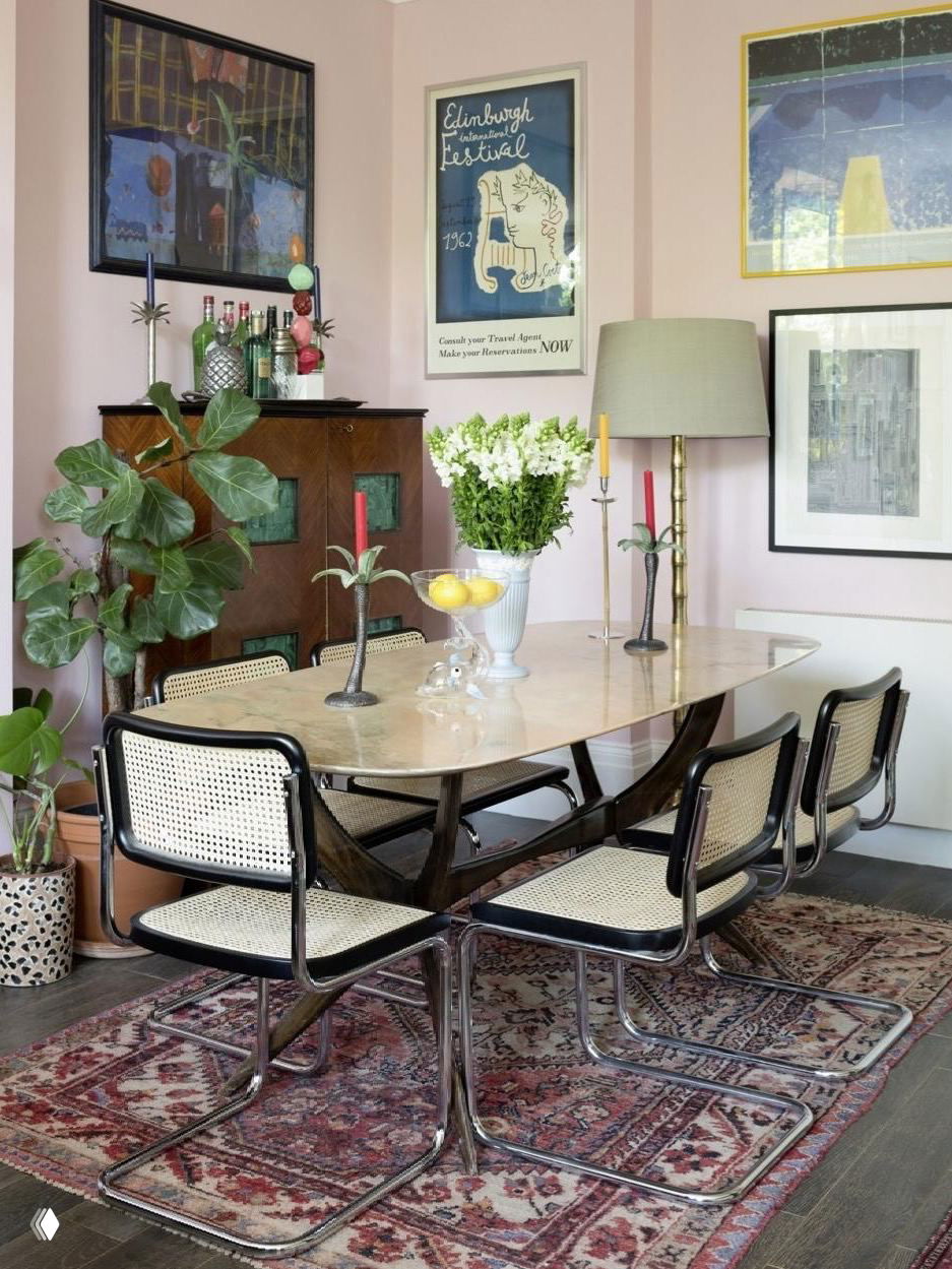 Столовая с мраморной столешницей и винтажным ковром под обеденным столом, показывающая сочетание текстур: камень, текстиль и тёплое дерево на полу.