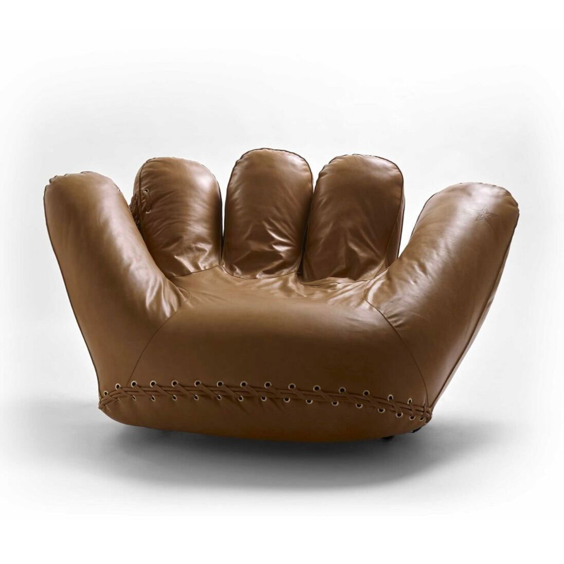 Фронтальный ракурс кресла Joe из коричневой кожи: очертания перчатки, выраженные «пальцы», низ с декоративной шнуровкой и ровная поверхность сиденья.