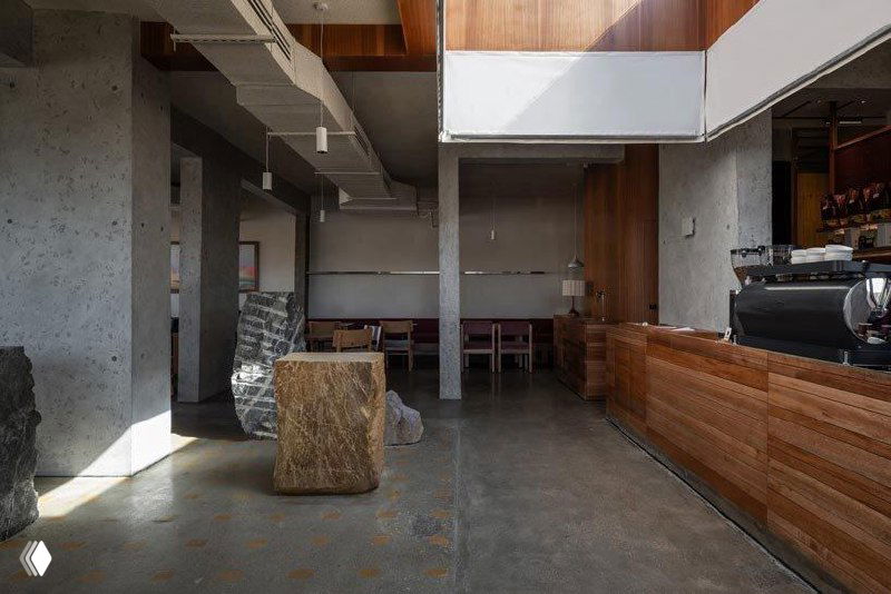 Интерьер кафе: барная зона и элементы отделки, фотография частично искажена цифровыми артефактами, видны грубые каменные фрагменты внутри зала.