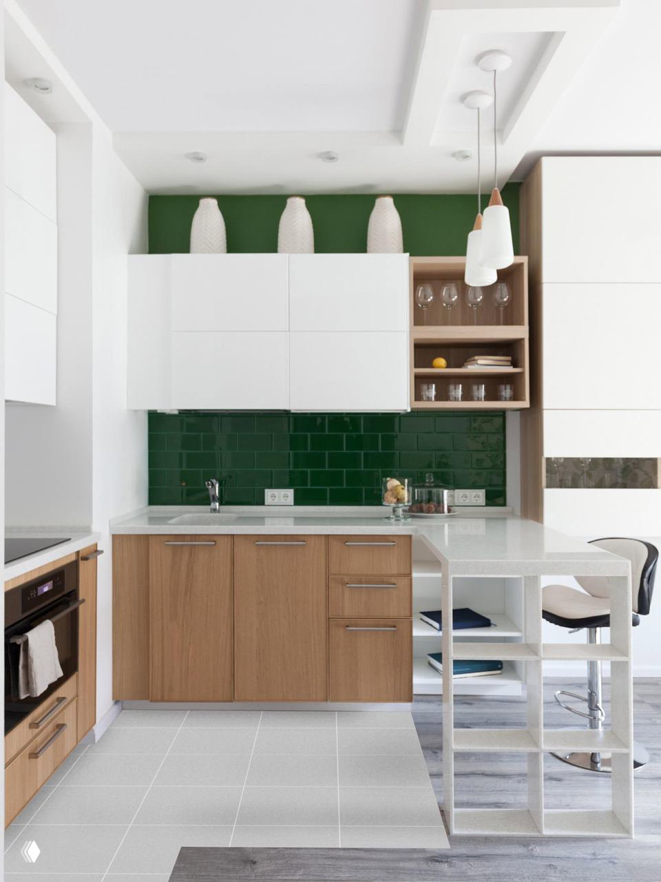 Современная светлая кухня: белые верхние шкафы, нижние из дерева и глянцевый тёмно‑зелёный фартук из прямоугольной плитки метро.