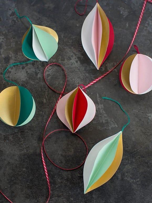 Набор бумажных объёмных шаров пастельных тонов на нитях — простая идея из бумаги для создания лёгких разноцветных игрушек.