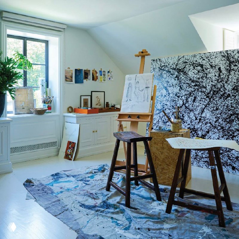 Ателье или рабочая комната с мольбертом, кистями и большим холстом, светлые стены и крашеный пол, творческая обстановка в мансарде