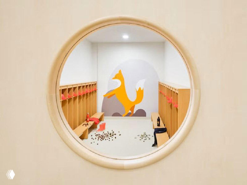 Детали оформления интерьера: мягкие подиумы, круговые сиденья и теплые акценты, создающие комфортную и гибкую среду для школьных активностей.