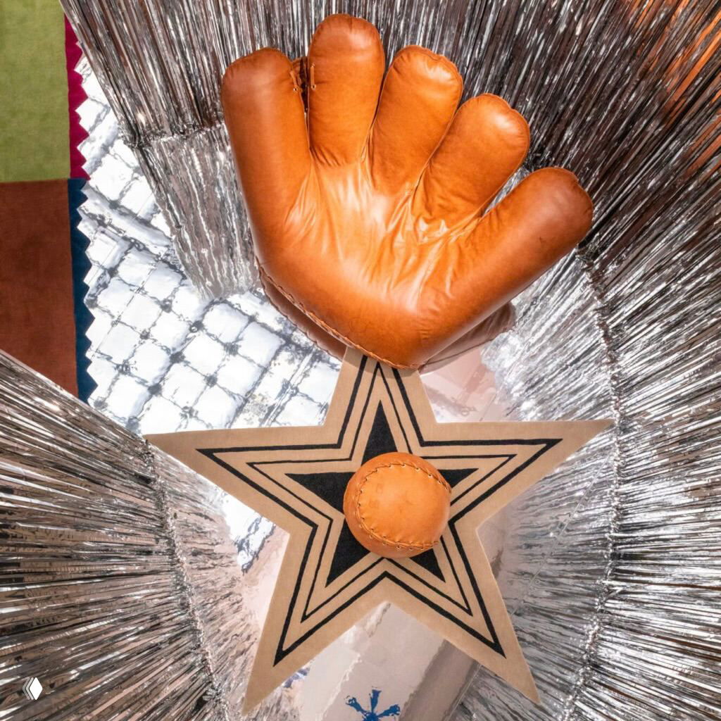 Вид сверху на кресло‑перчатку и круглый пуф, расположенные на ковре со звездой; композиция демонстрирует масштаб и оформление предметов мебели.