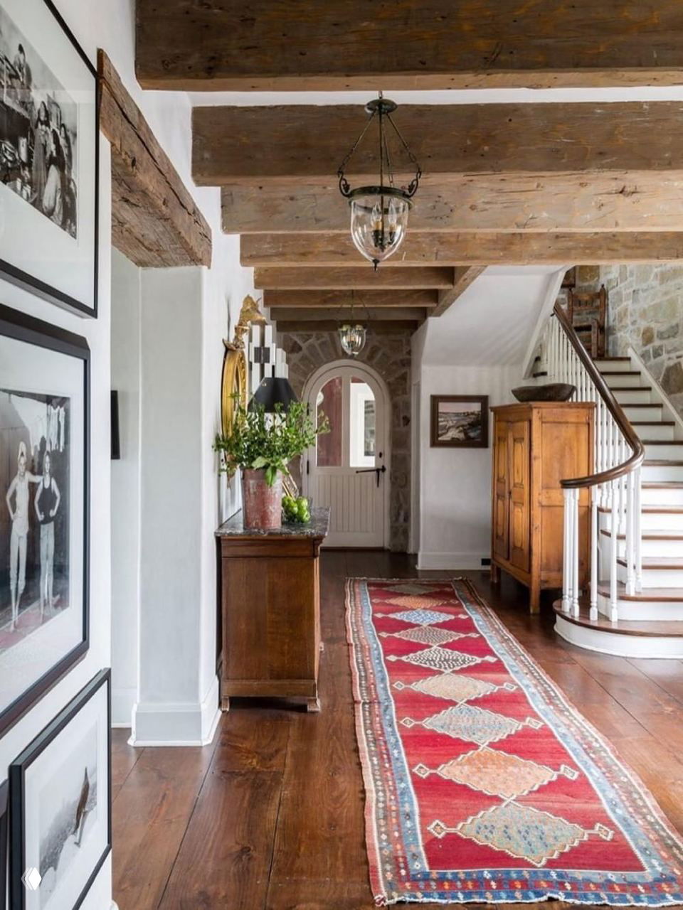 Прихожая с тёплой деревянной доской и длинной цветной дорожкой‑килимом, иллюстрирующая сочетание натурального дерева и декоративных ковровых вставок.
