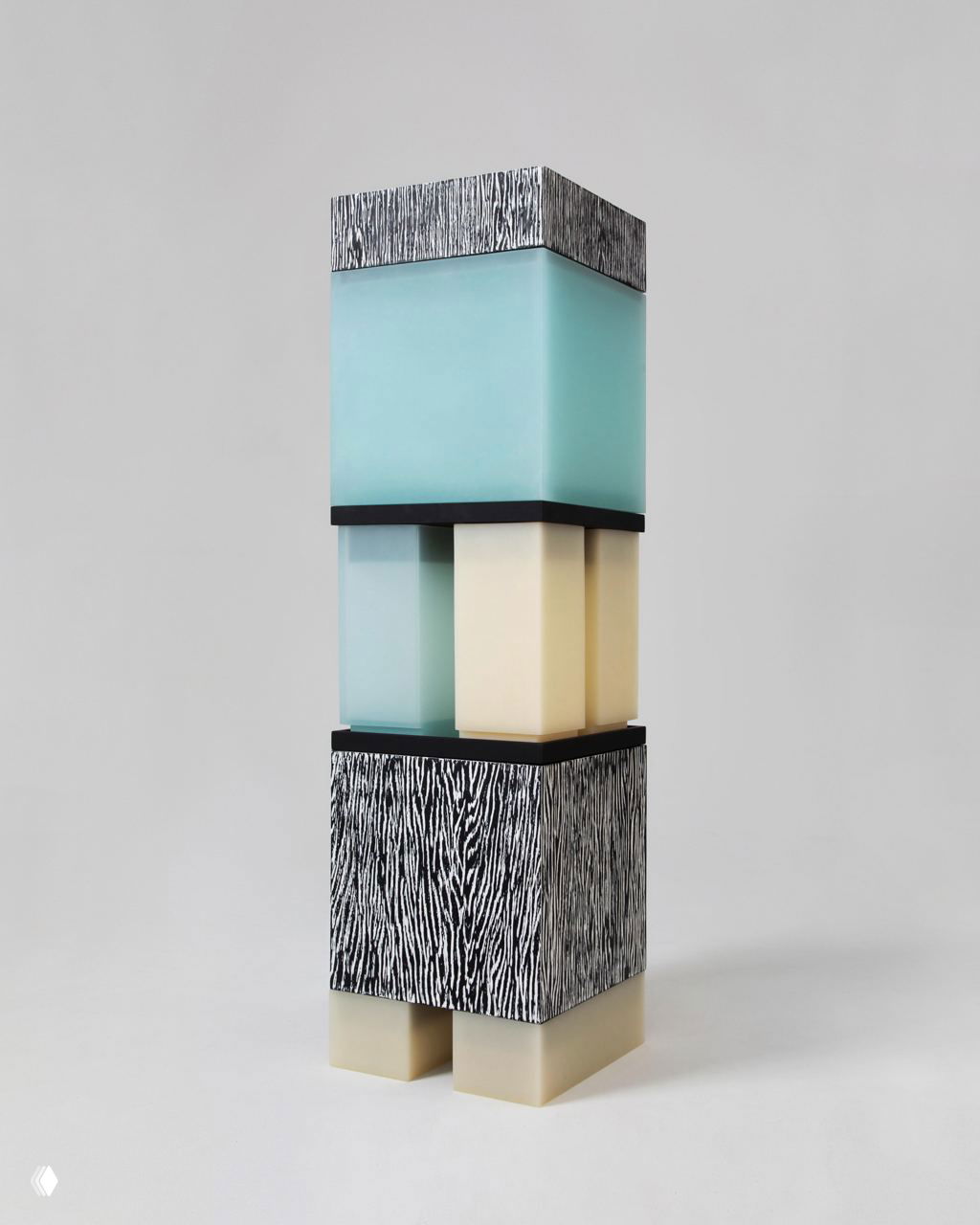 Общий ракурс тотема Tons под углом: прозрачные и матовые слои, контрастный узорный короб в основании и светлые пластичные опоры, показывающие модульность элементов.
