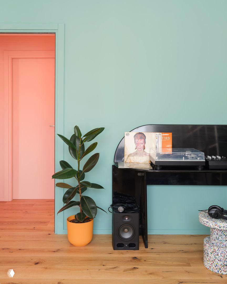 Уголок с проигрывателем винила, плакатом Дэвида Боуи, горшечной растением и мятной стеной — музыкальные акценты в квартире меломана.