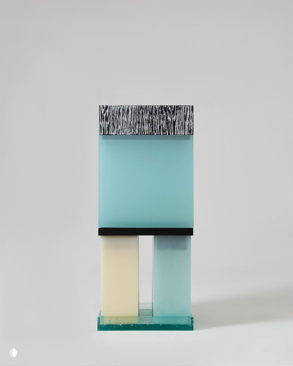 Фронтальный вид тотема: верхний большой бирюзовый блок на двух колоннах‑опорах и узорная нижняя коробка, чистый фон подчёркивает геометрические пропорции.