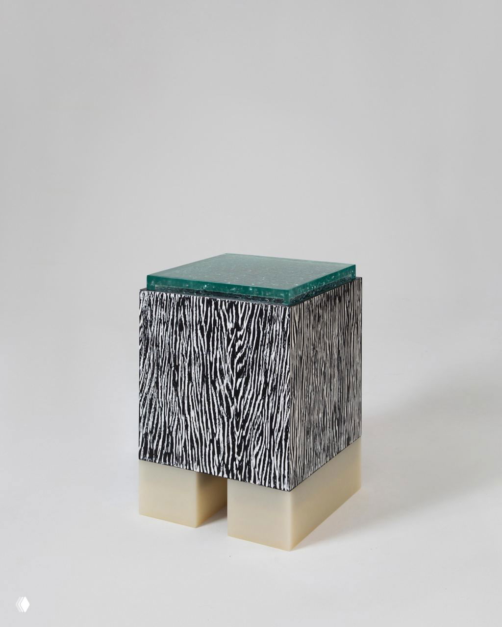 Низкий куб‑бокс из коллекции Tons: декоративный черно‑белый шпон по бокам и светлые резиновые или смоляные опоры, демонстрация текстуры и модульности деталей.