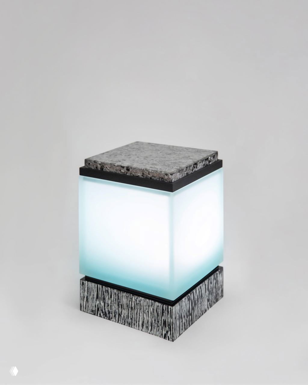 Светящийся куб‑светильник из коллекции Tons: матовое полупрозрачное стекло с равномерной подсветкой, сверху — грубая текстурированная крышка и низ с узорным шпоновым основанием.
