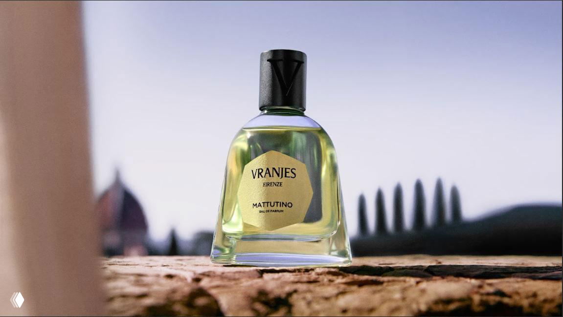 Крупный план флакона Dr. Vranjes Mattutino на фоне размытых силуэтов Флоренции и кипарисов, подчёркнутый мягким дневным светом.