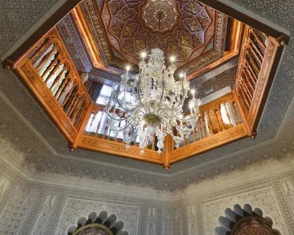 Интерьер с декоративным резным куполом и крупной хрустальной люстрой в марокканском стиле — деталь потолка и орнамента в гостиной замка