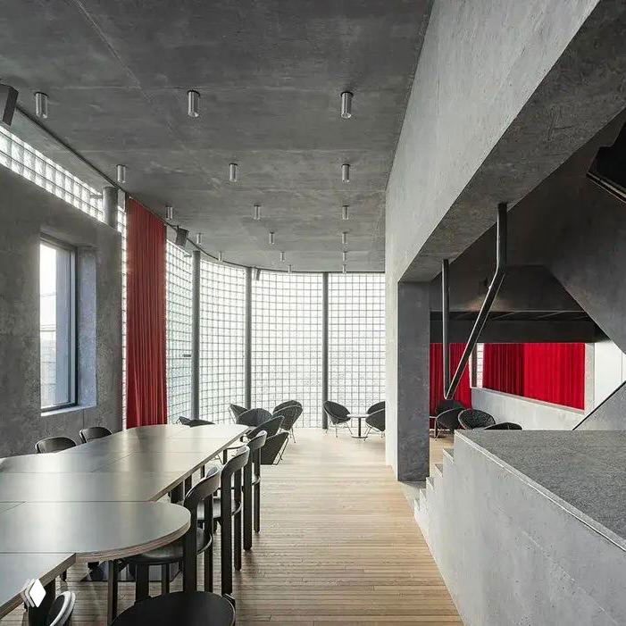 Интерьер с панелями из стеклоблоков, деревянным полом и столовой зоной: свет проходит через стекло, создавая мягкую атмосферу пространства.