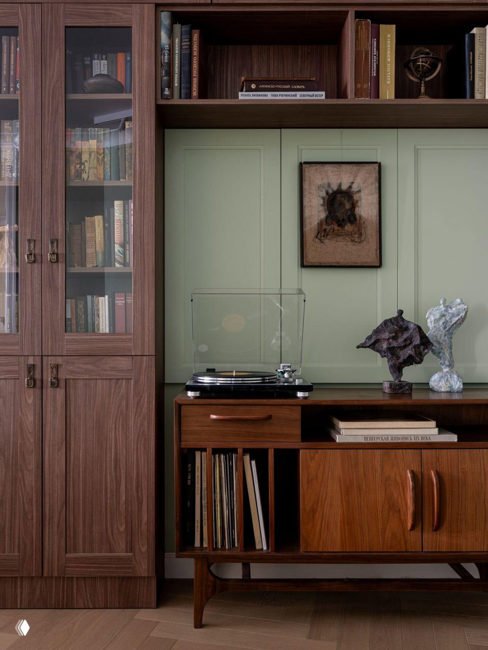 Книжный шкаф с секциями для виниловых пластинок и стеллажами для книг; ретро-тумба с проигрывателем и коллекцией графики на стене.