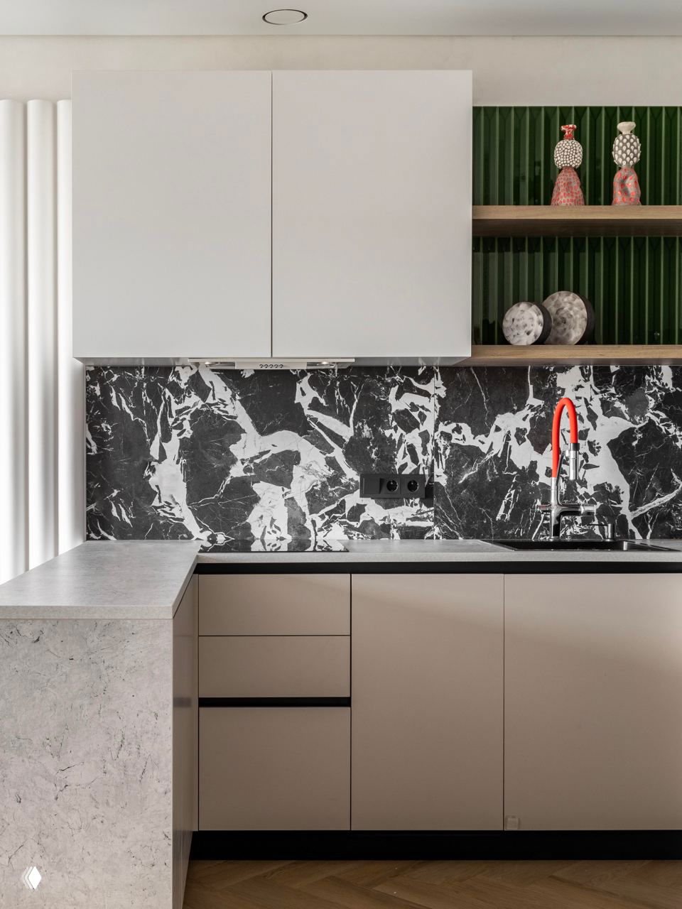 Фартук кухни с чёрно‑белым мраморным рисунком, светлые фасады, деревянные полки и красный излив смесителя как яркий акцент интерьера.