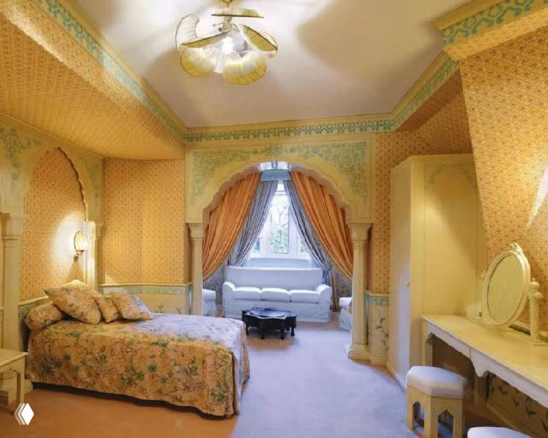 Интерьерная фотография коридора или зала с витражной панелью, креслами и столиками — декоративные элементы в общественной части замка