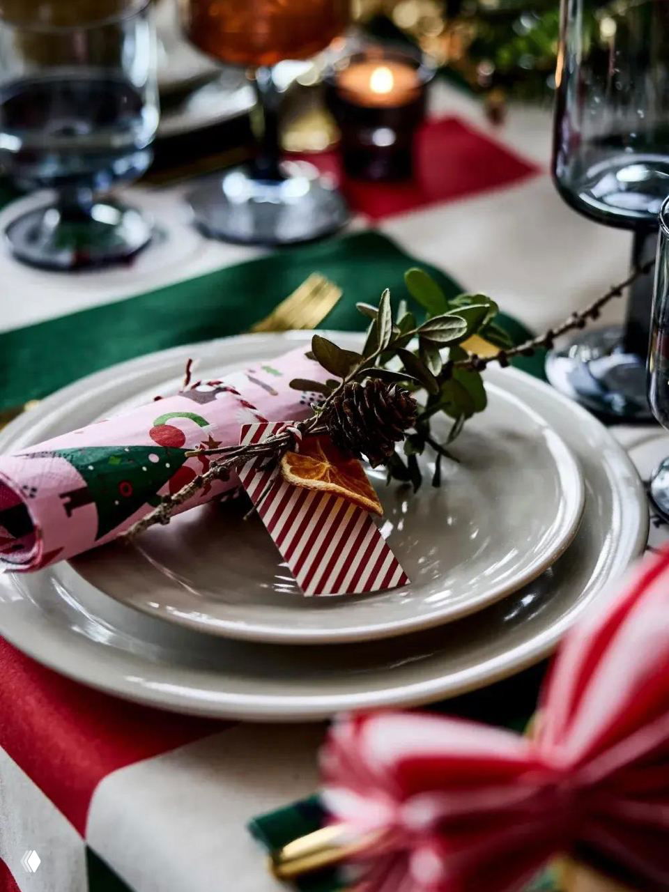 Ближе к столовой сервировке: белая тарелка, простая льняная салфетка с аккуратной вышивкой и золотой столовый прибор — универсальный вариант для праздника.