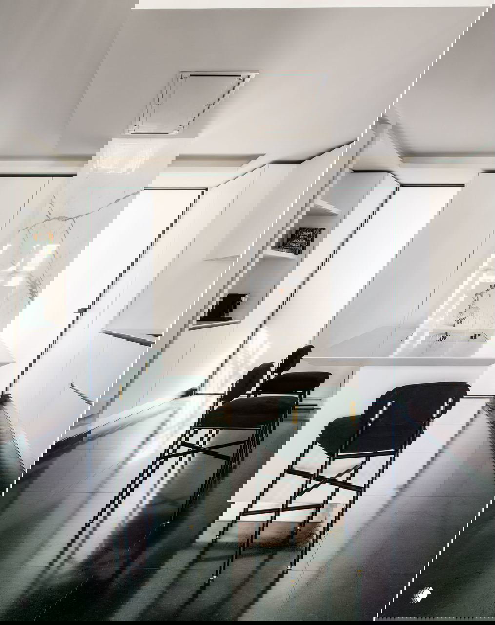 Минималистичная светлая кухня с островом, барными стульями и мраморным фартуком — пример чистого скандинавского/итальянского интерьера с минимумом деталей.