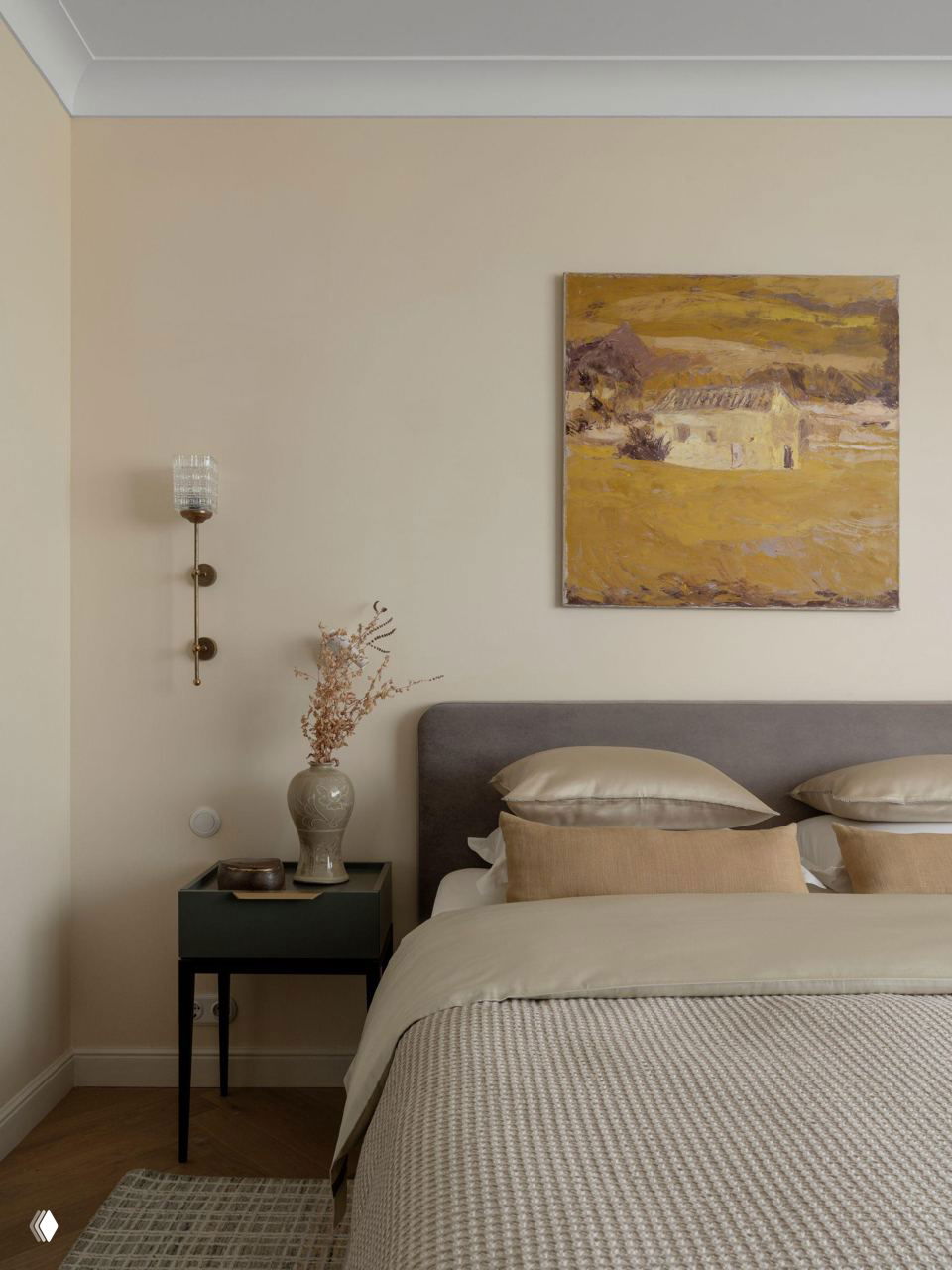 Спальня в спокойной бежевой палитре: аккуратная кровать с текстильными слоями, картина над изголовьем и минимальная прикроватная мебель.