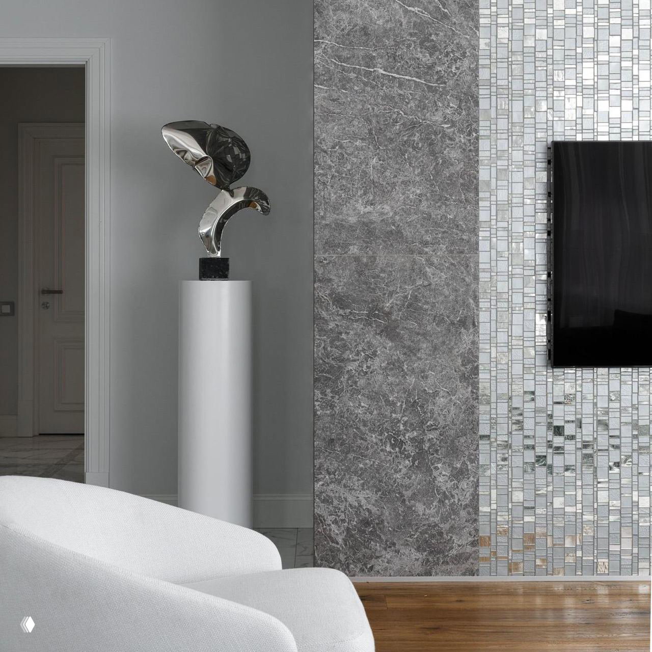 Современный интерьер с серебристой скульптурой, мраморной плиткой и белыми креслами — акцент на металле.