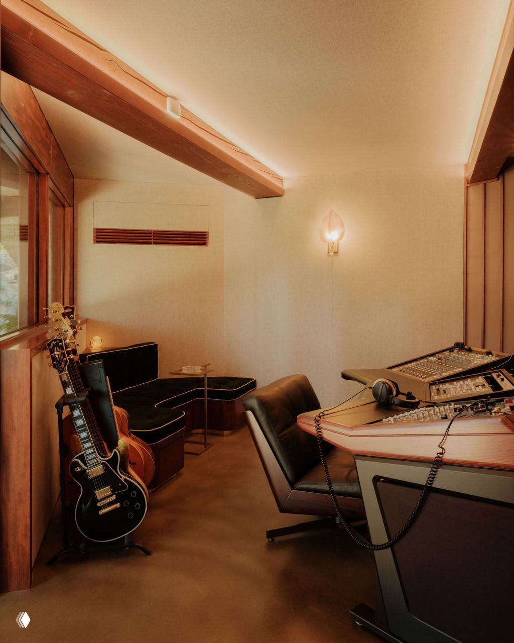 Музыкальная комната с микшёрным столом, гитарами и уютными диванами — пространство для работы и творчества в доме музыканта.