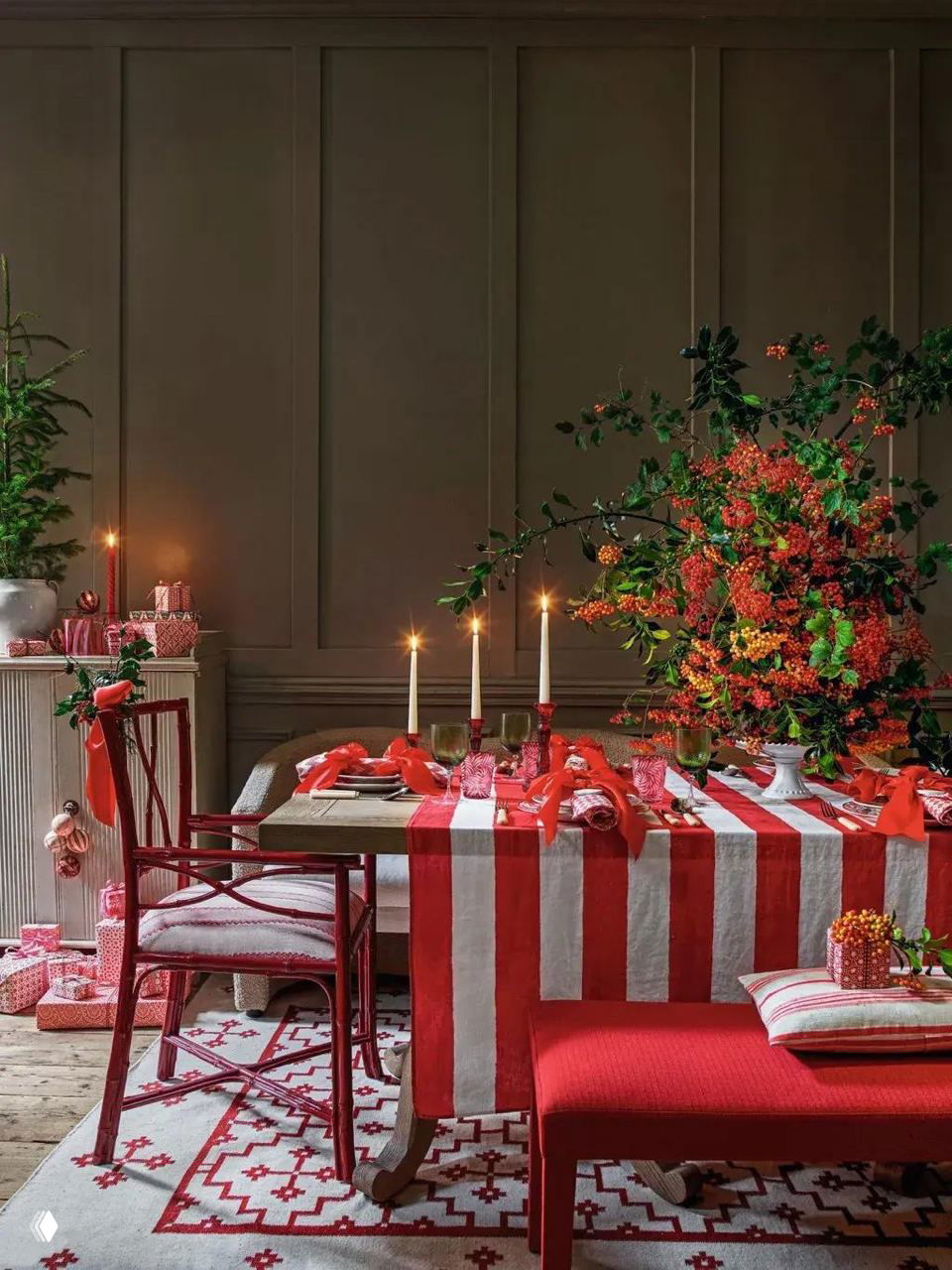 Полный вид праздничного стола с красно-белой полосатой скатертью, свечами и крупной цветочной композицией — эффектная центральная композиция для торжества.