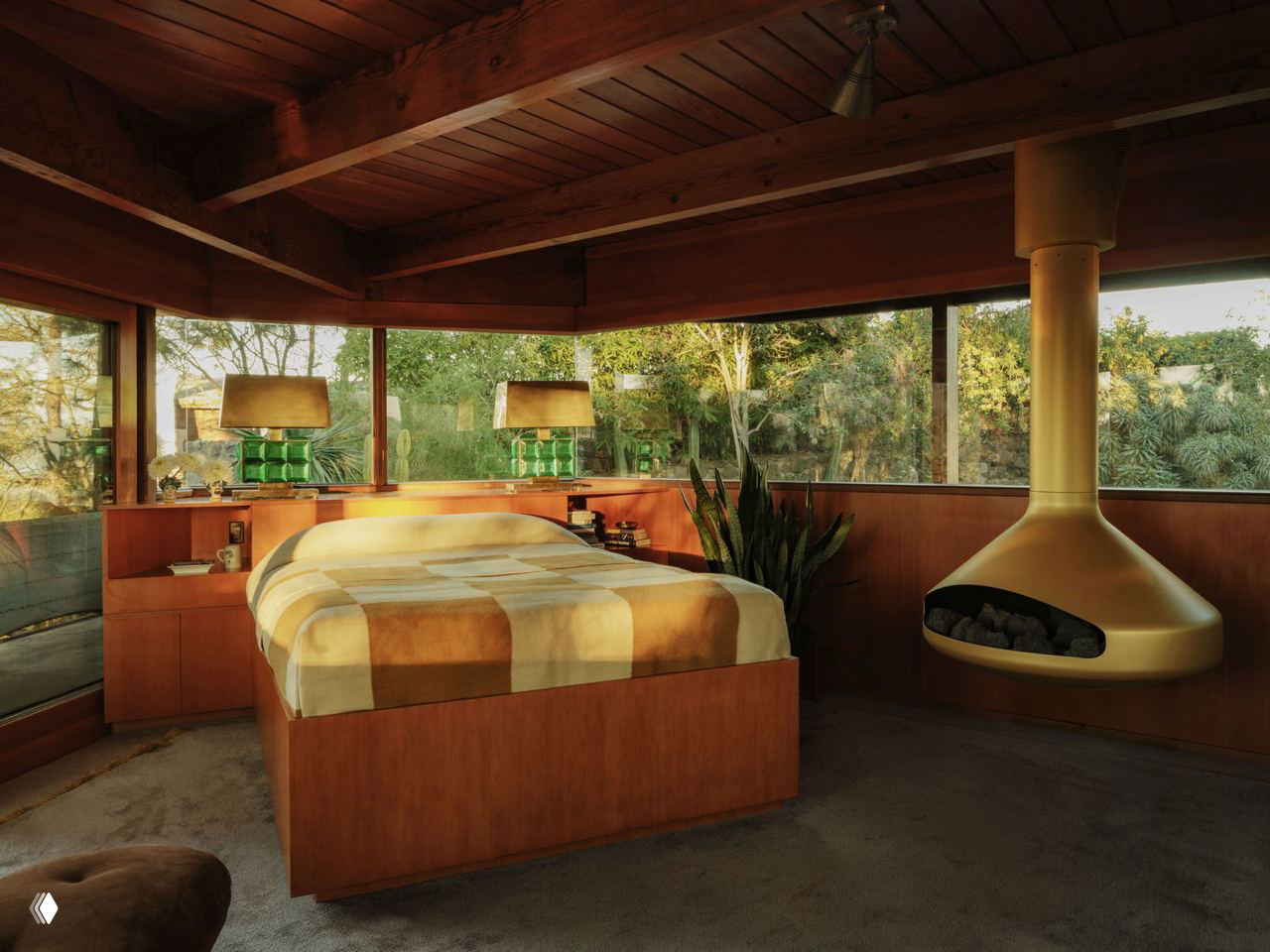 Спальня с панорамными окнами, подвесной металлической печью, деревянной мебелью и тёплым естественным освещением на фоне зелёного сада.