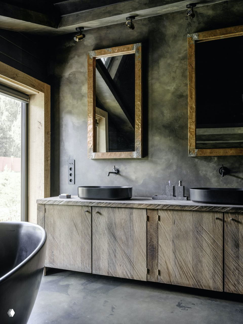 Ванная комната с деревянной тумбой, двумя зеркалами и чёрными раковинами на фоне декоративной штукатурки и крупной сантехники.
