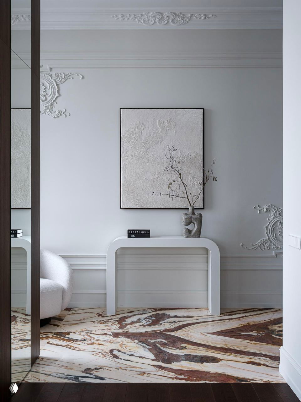 Камин с барочными элементами и большим позолоченным зеркалом над полкой, свечи и декоративные объекты у основания, тонкая лепнина вокруг проёма.