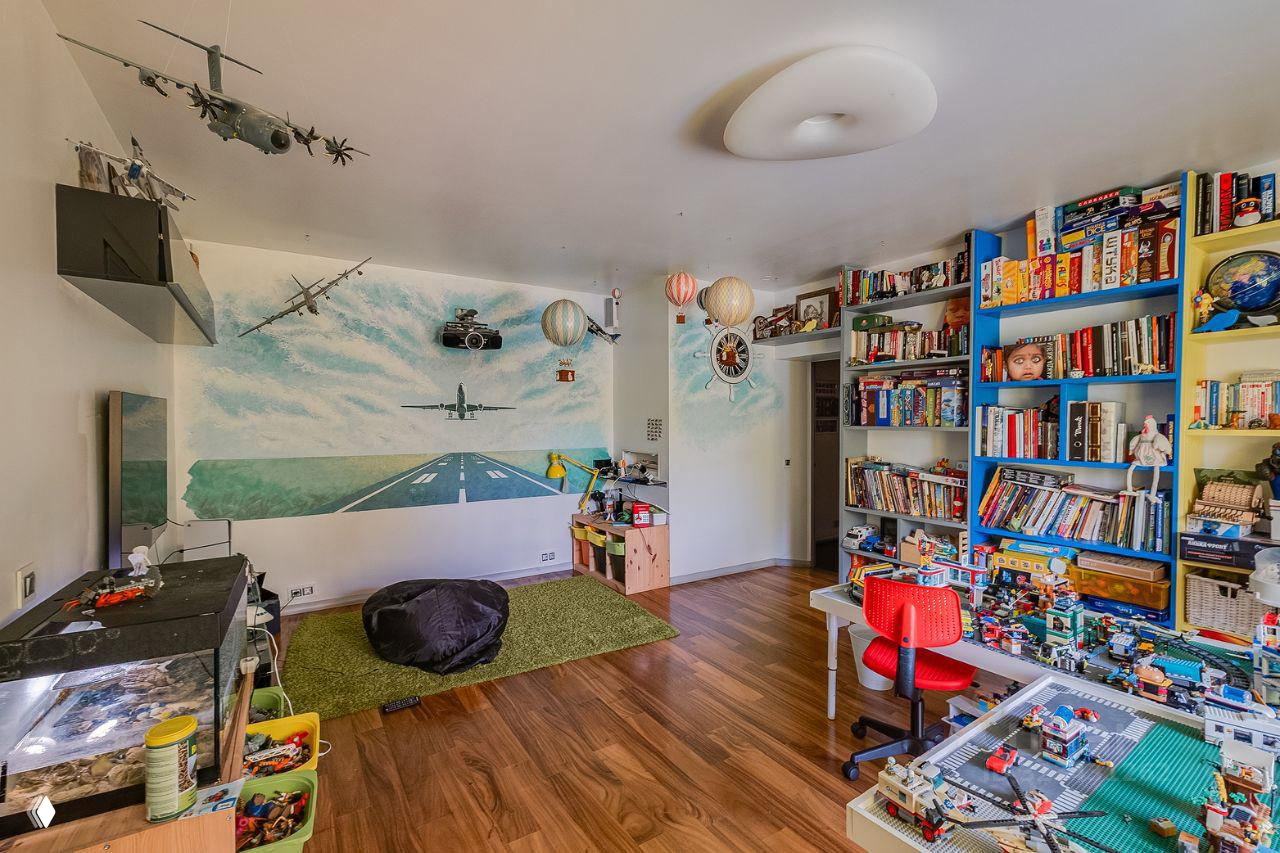 Вторая детская с настенной росписью в авиационной тематике, просторным игровым уголком, большим стеллажом с книгами и развивающими играми.