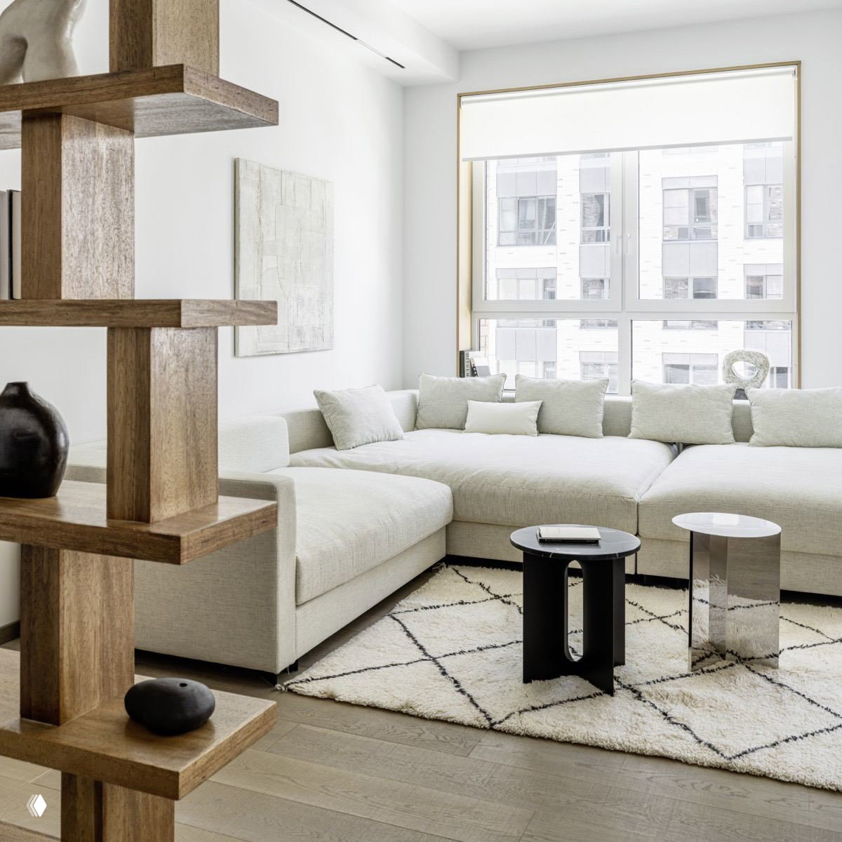 Светлая гостиная со светло-бежевым модульным диваном, текстурным ковром и деревянными перегородками, теплый скандинавский акцент.