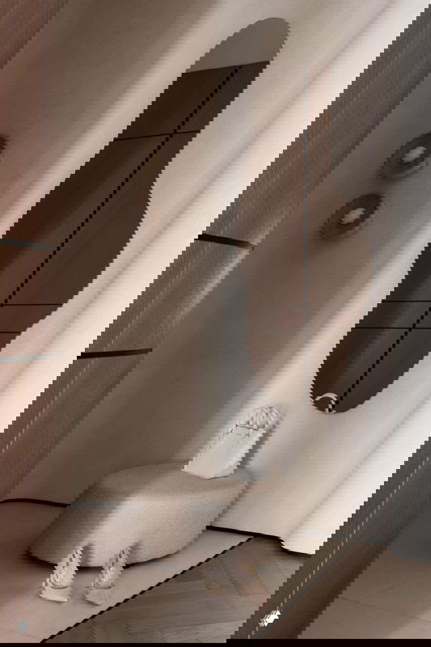 Прихожая с органическим зеркалом, округлым пуфом, сумкой и туфлями на полу — мягкие формы и натуральные текстуры в проекте Алуа Балгереевой.