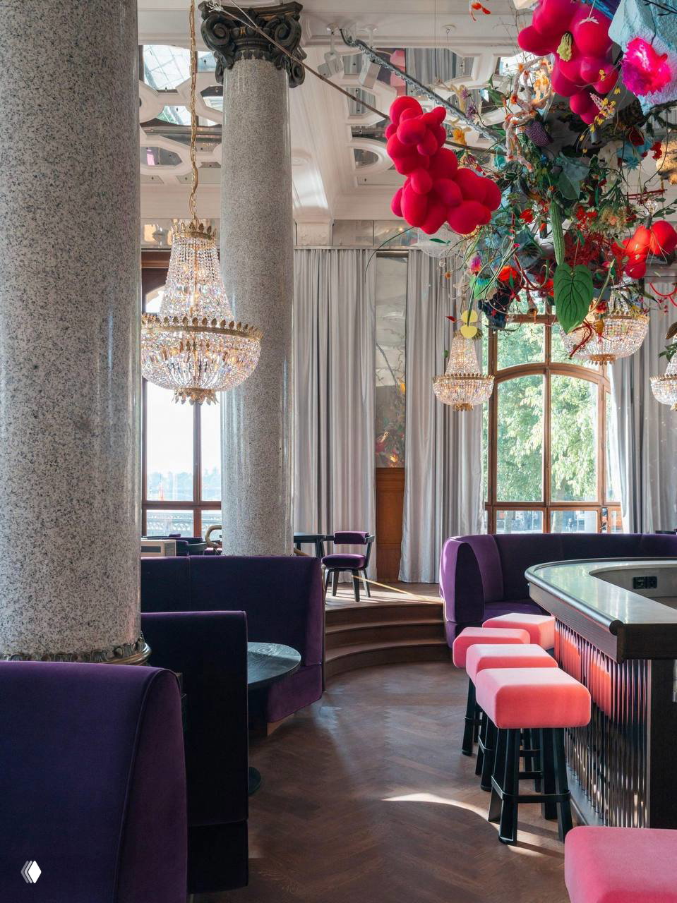 Крупный план зала: массивные гранитные колонны, хрустальные люстры, фиолетовые диваны и ритмичный «кружевной» паркет в новом интерьере Les Trois Rois.