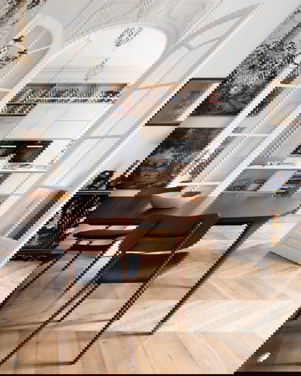 Классический интерьер с арочными дверями и видимой кухней с фасадами из фанеры: интегрированные приборы, открытые полки для книг и плавный переход в столовую зону.