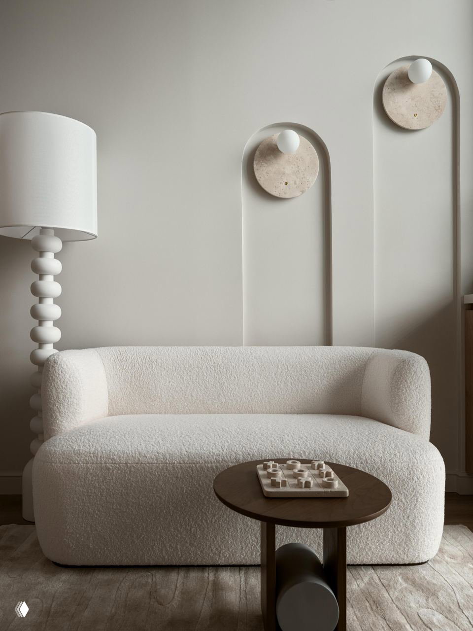 Маленький диван в текстурной обивке на фоне оформленных ниш на стене: спокойные пастельные тона и скульптурные настенные светильники создают японскую атмосферу.