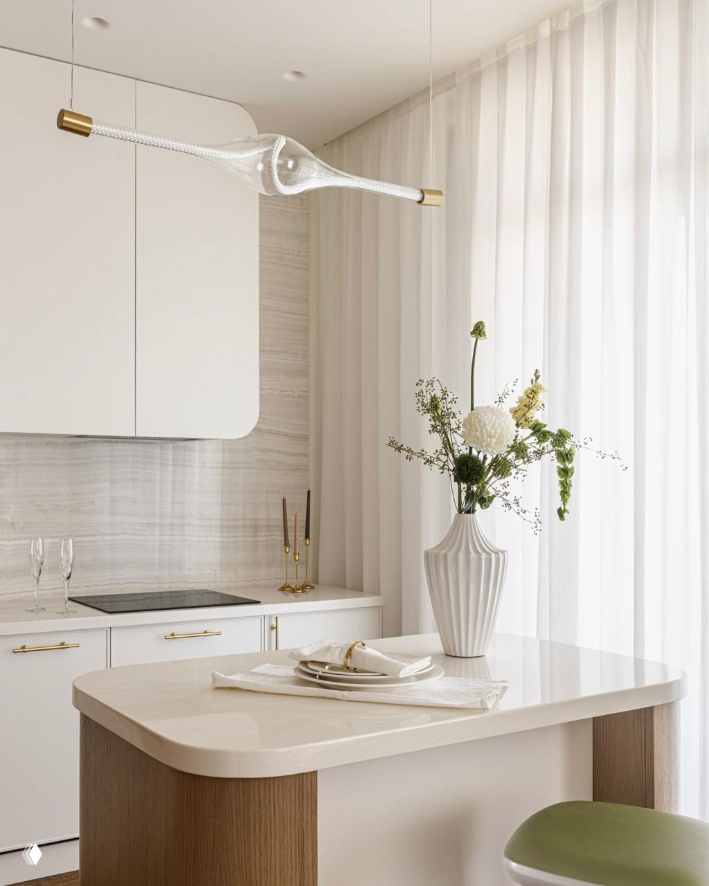 Крупный план столешницы и декора у окна: тонкая ваза с цветами, светлый мраморный фон и прозрачный подвесной светильник с латунными деталями.