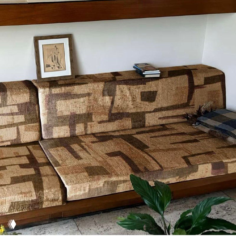 Текстильное покрытие и мебельная ткань в тёплой палитре: диван с узорчатым покрытием в интерьере стенда Heimtextil, фото частично искажено