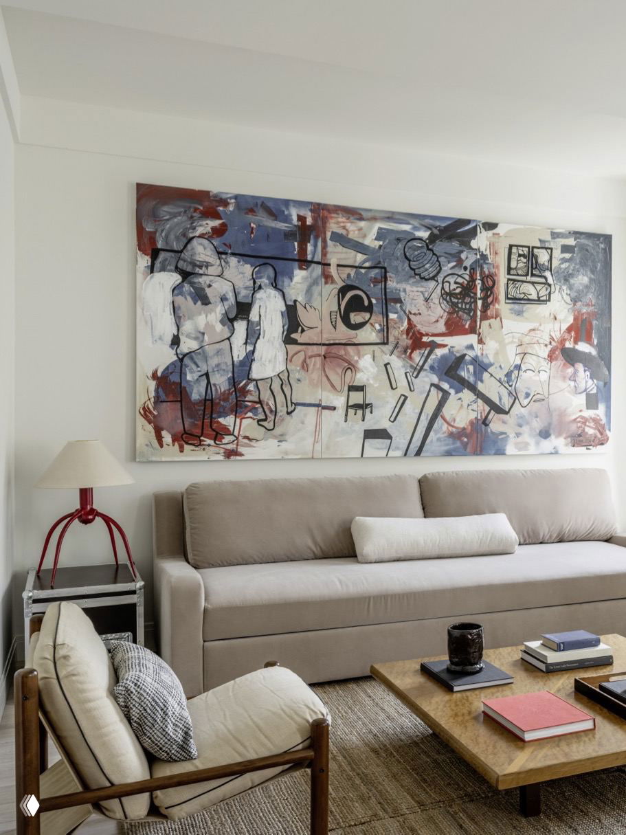 Минималистичная гостиная в светлых тонах с большим абстрактным панно над диваном, нейтральной мебелью и журнальным столиком — художественный акцент стен.