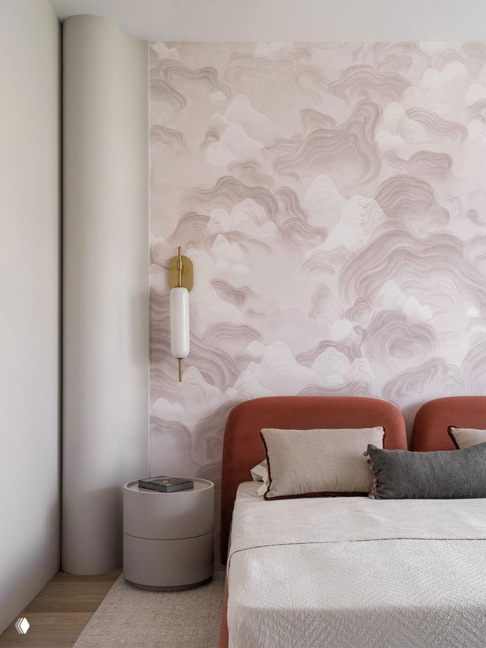 Спальня с пастельной росписью на стене, мягким изголовьем терракотового оттенка и лаконичной тумбой — уютный приватный интерьер.