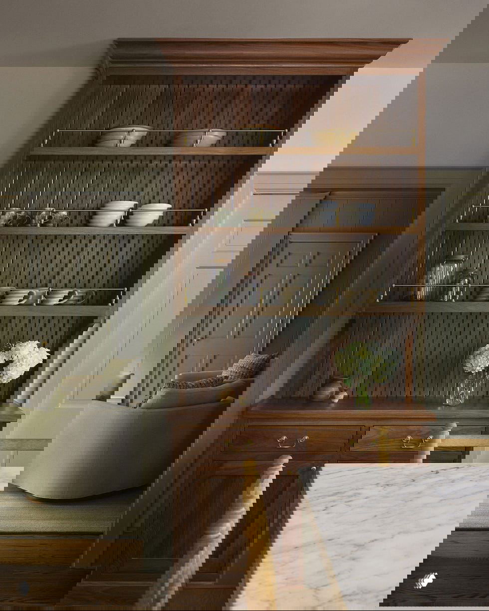 Кухонный уголок с деревянной столешницей, открытыми полками и мраморной поверхностью рабочей зоны, продуманное хранение и тёплая натуральная палитра материалов.