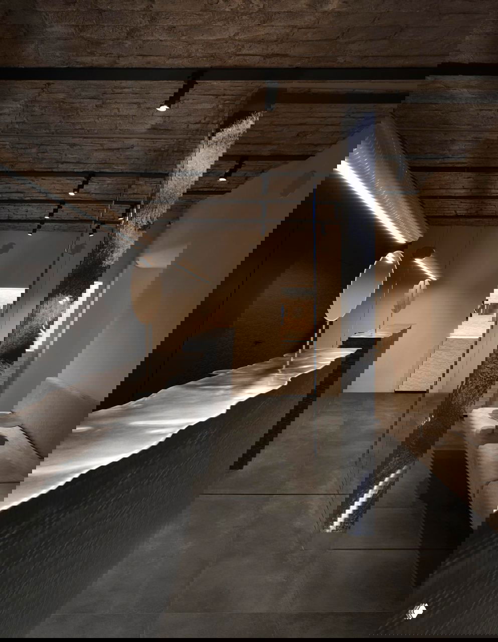 Контрастная зона бутика с тёмным прилавком, зеркальной колонной и открытой кирпичной потолочной поверхностью — сочетание грубой текстуры и тонкой геометрии.