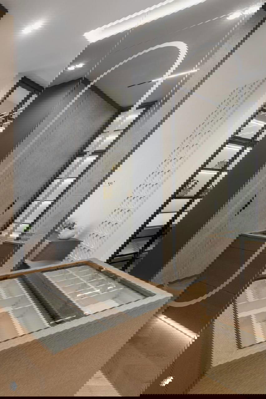 Гардеробная/прихожая с зеркалом в рост и организованной системой хранения; деревянные и стеклянные фасады на фоне подсветки.