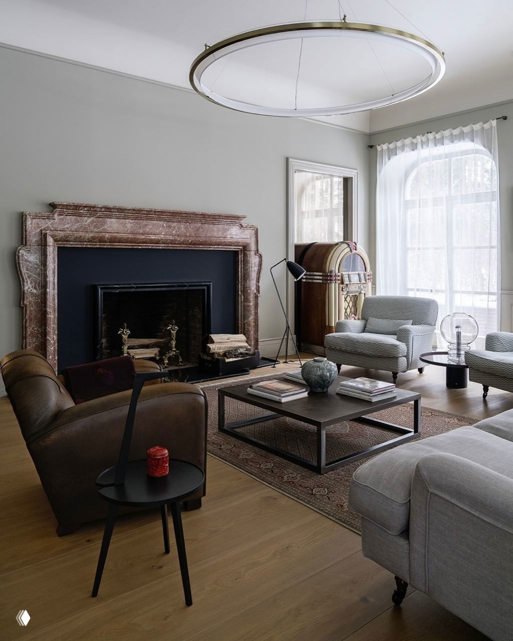 Светлая гостиная с мраморным камином и коричневыми мебельными акцентами: сочетание серых и коричневых оттенков для современного классического интерьера.